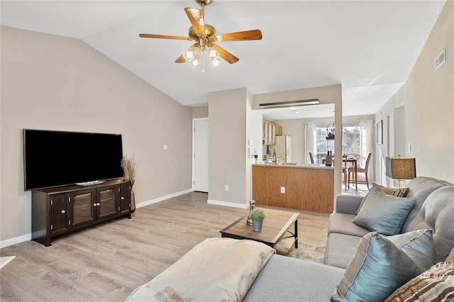 living room featuring vaulted ceiling, ceiling fan, and light hardwood / wood-style flooring