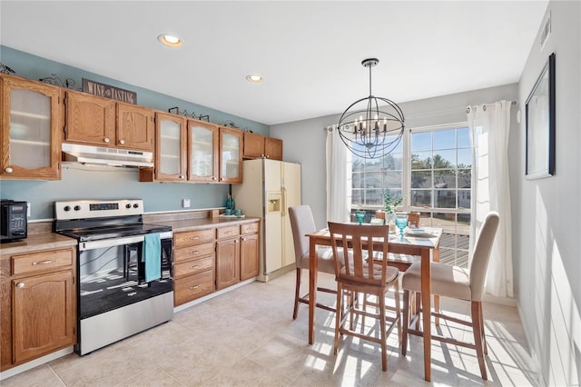 kitchen with hanging light fixtures, electric range, white refrigerator with ice dispenser, and a notable chandelier