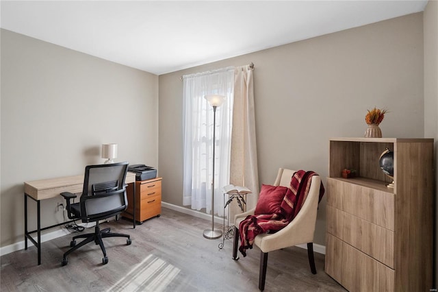 home office with light hardwood / wood-style flooring