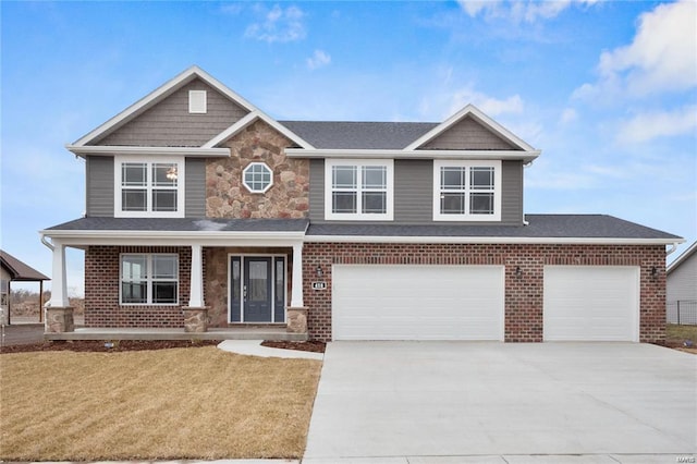 craftsman inspired home with a front lawn, a garage, and covered porch