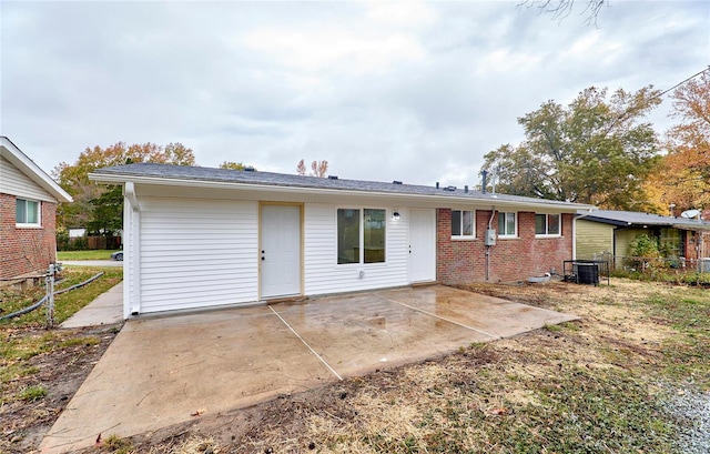 rear view of property with central AC unit and a patio area