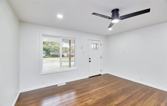 empty room featuring dark wood-type flooring and ceiling fan