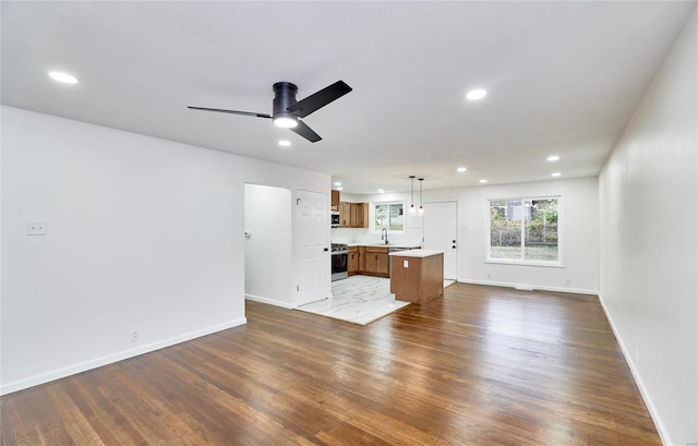 unfurnished living room featuring dark wood-type flooring, sink, and ceiling fan