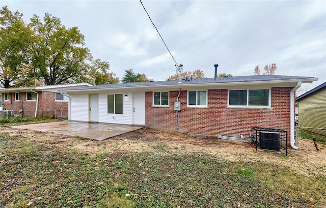 rear view of property featuring central AC unit, a patio, and a lawn