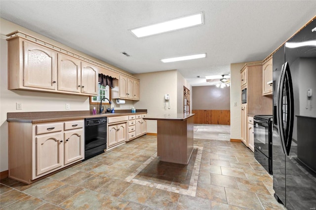 kitchen with black appliances, a textured ceiling, wood walls, a kitchen island, and light brown cabinets