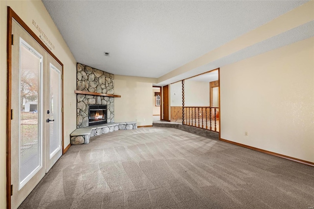 unfurnished living room featuring carpet, a fireplace, and a textured ceiling