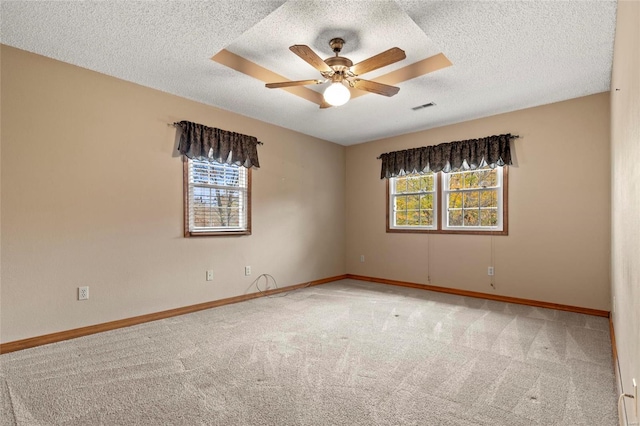 carpeted empty room with plenty of natural light, a textured ceiling, and ceiling fan