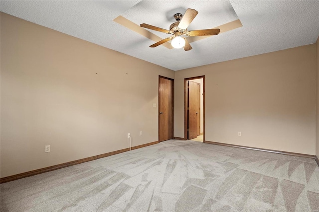 empty room with light colored carpet, a textured ceiling, and ceiling fan