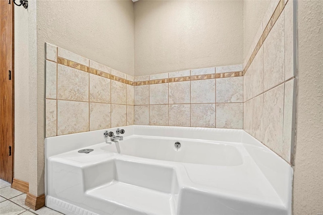 bathroom with a bath and tile patterned floors