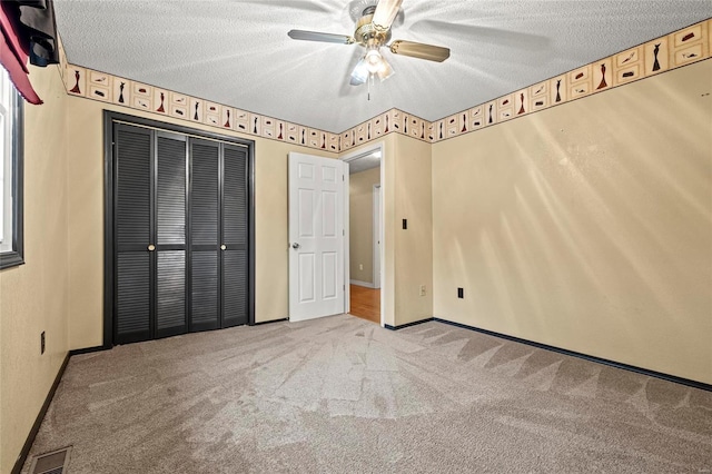 unfurnished bedroom with a closet, a textured ceiling, light carpet, and ceiling fan