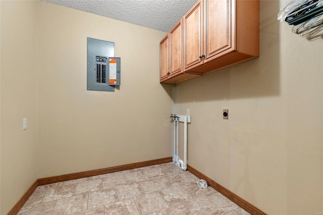 clothes washing area featuring electric panel, cabinets, a textured ceiling, and hookup for an electric dryer