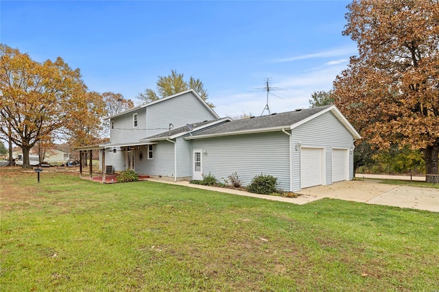 back of property featuring a garage and a yard