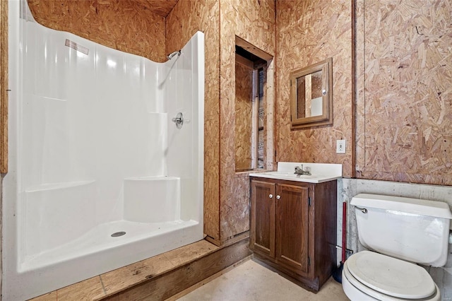 bathroom featuring toilet, a shower, and vanity