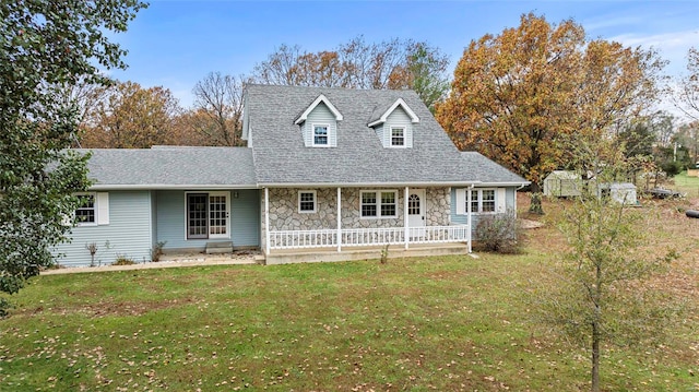 view of front of house featuring a porch, a front yard, and a storage shed