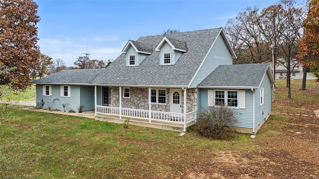 new england style home with covered porch and a front yard