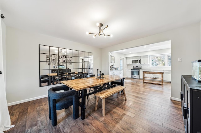 dining area featuring wood-type flooring and an inviting chandelier