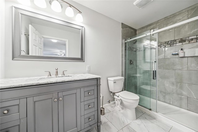 bathroom featuring vanity, toilet, and a shower with shower door