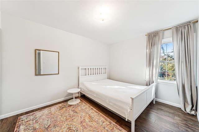 bedroom with dark hardwood / wood-style flooring