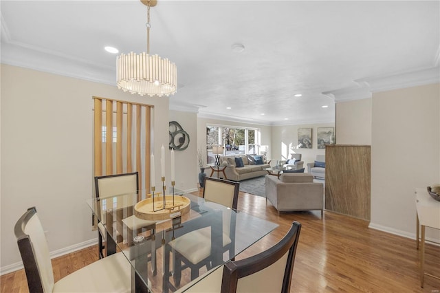 dining area with baseboards, crown molding, and light wood finished floors