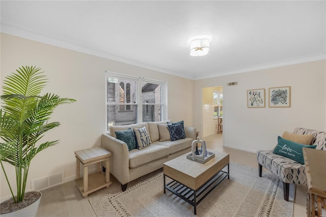 living room with ornamental molding, visible vents, and baseboards