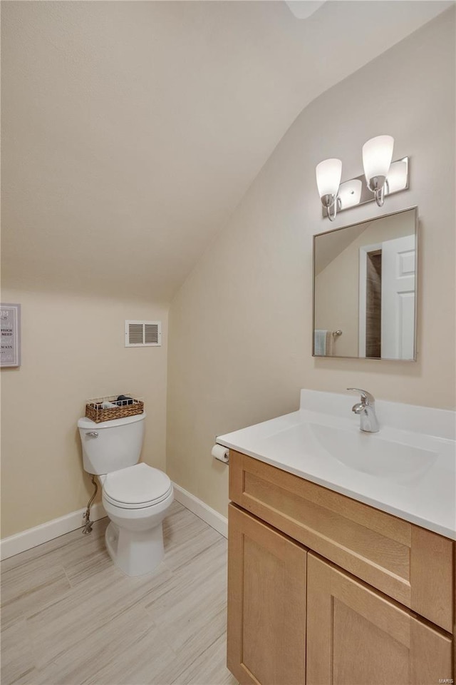 bathroom with visible vents, vaulted ceiling, vanity, and toilet