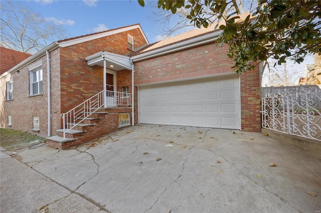 view of front of property with driveway, a garage, fence, and brick siding