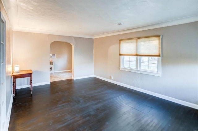 empty room with dark wood-type flooring and ornamental molding