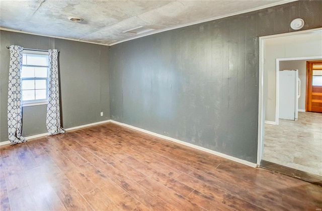 unfurnished room with hardwood / wood-style floors and wood walls