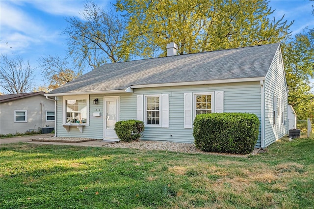 ranch-style home with central air condition unit and a front yard