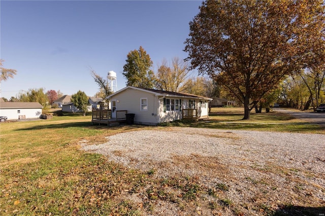 view of side of home with a deck and a yard