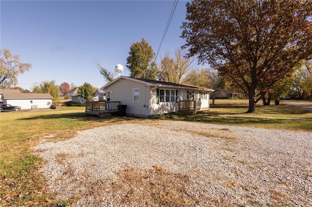 view of front of house featuring a front lawn and a wooden deck