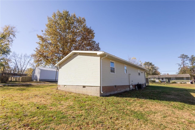 view of side of home featuring central AC and a yard