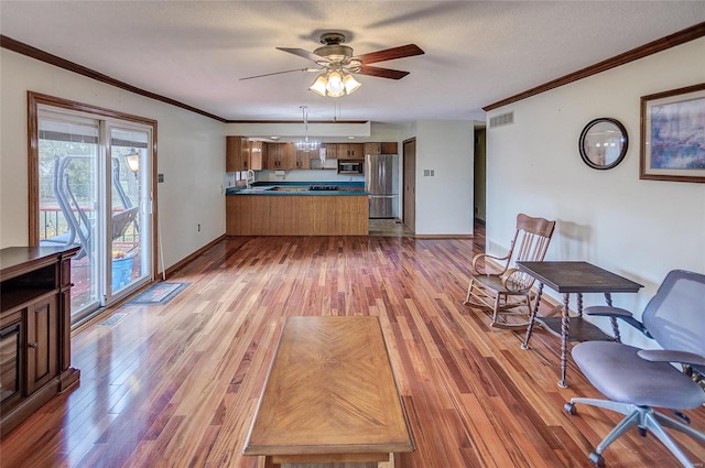 interior space featuring ornamental molding, light wood-type flooring, and stainless steel appliances