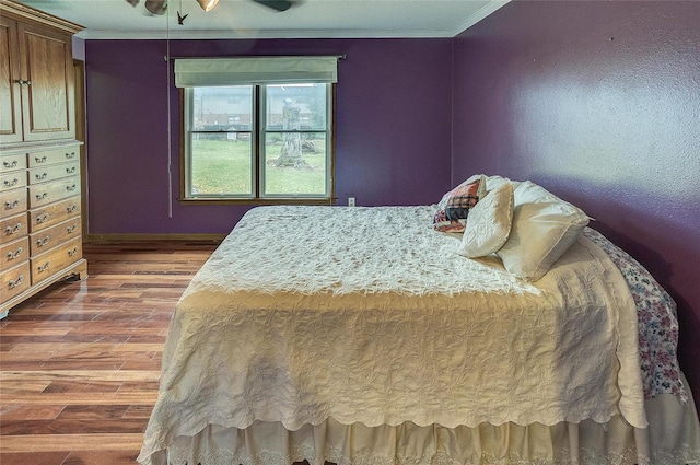 bedroom with ceiling fan, dark hardwood / wood-style floors, and crown molding