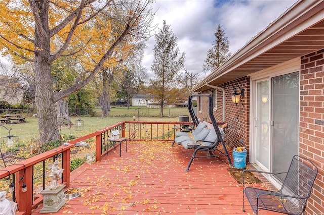 wooden deck featuring a lawn