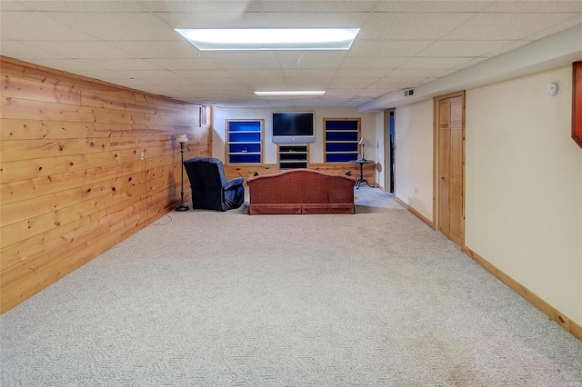 interior space with wood walls, a paneled ceiling, and carpet