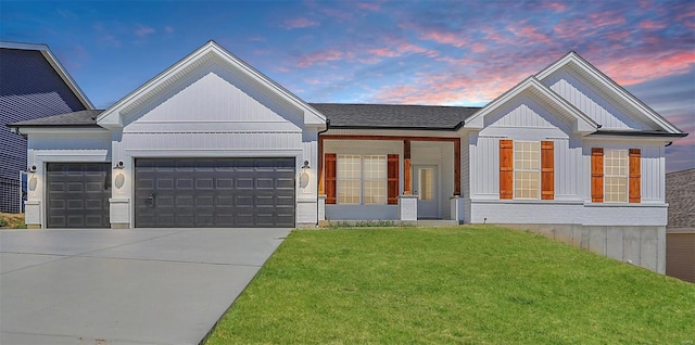 view of front of property featuring a garage and a lawn