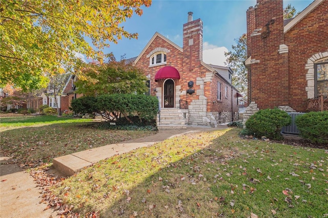 tudor-style house featuring a front yard