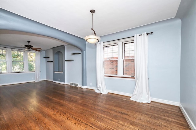 empty room with ceiling fan and dark hardwood / wood-style floors