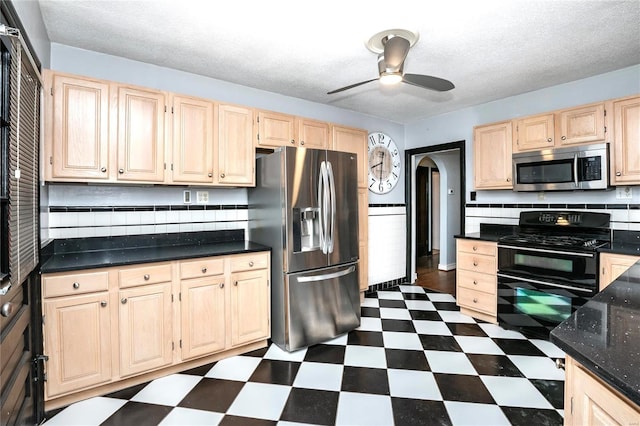 kitchen with stainless steel appliances, decorative backsplash, a textured ceiling, ceiling fan, and light brown cabinets