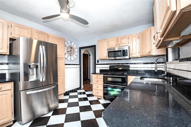 kitchen with stainless steel appliances, light brown cabinetry, ceiling fan, and sink