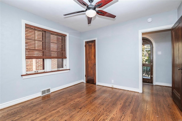 empty room featuring dark wood-type flooring and ceiling fan