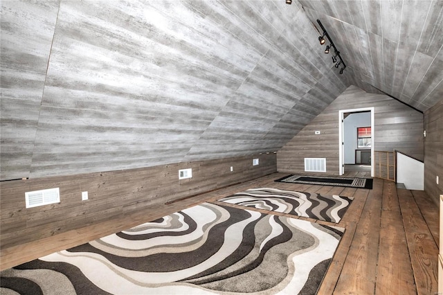 bonus room with wood walls, hardwood / wood-style flooring, and vaulted ceiling