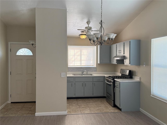 kitchen featuring hanging light fixtures, a healthy amount of sunlight, a chandelier, and stainless steel gas stove