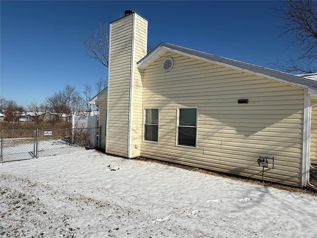 view of snow covered rear of property