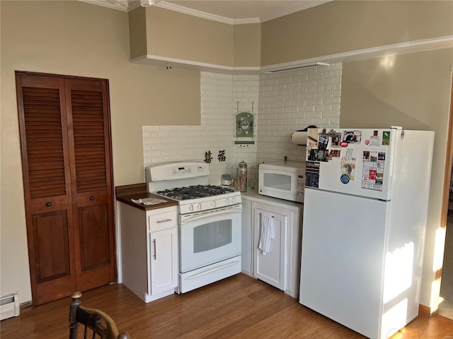 kitchen with light hardwood / wood-style floors, ornamental molding, white cabinetry, and white appliances