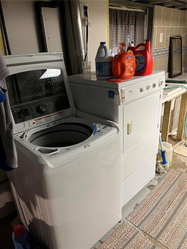 clothes washing area with separate washer and dryer