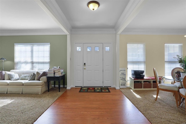 foyer with hardwood / wood-style flooring and crown molding