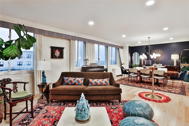 living room with a chandelier, hardwood / wood-style floors, and crown molding