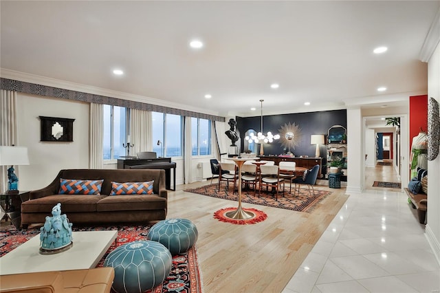 living room featuring ornamental molding, light wood-type flooring, and a notable chandelier